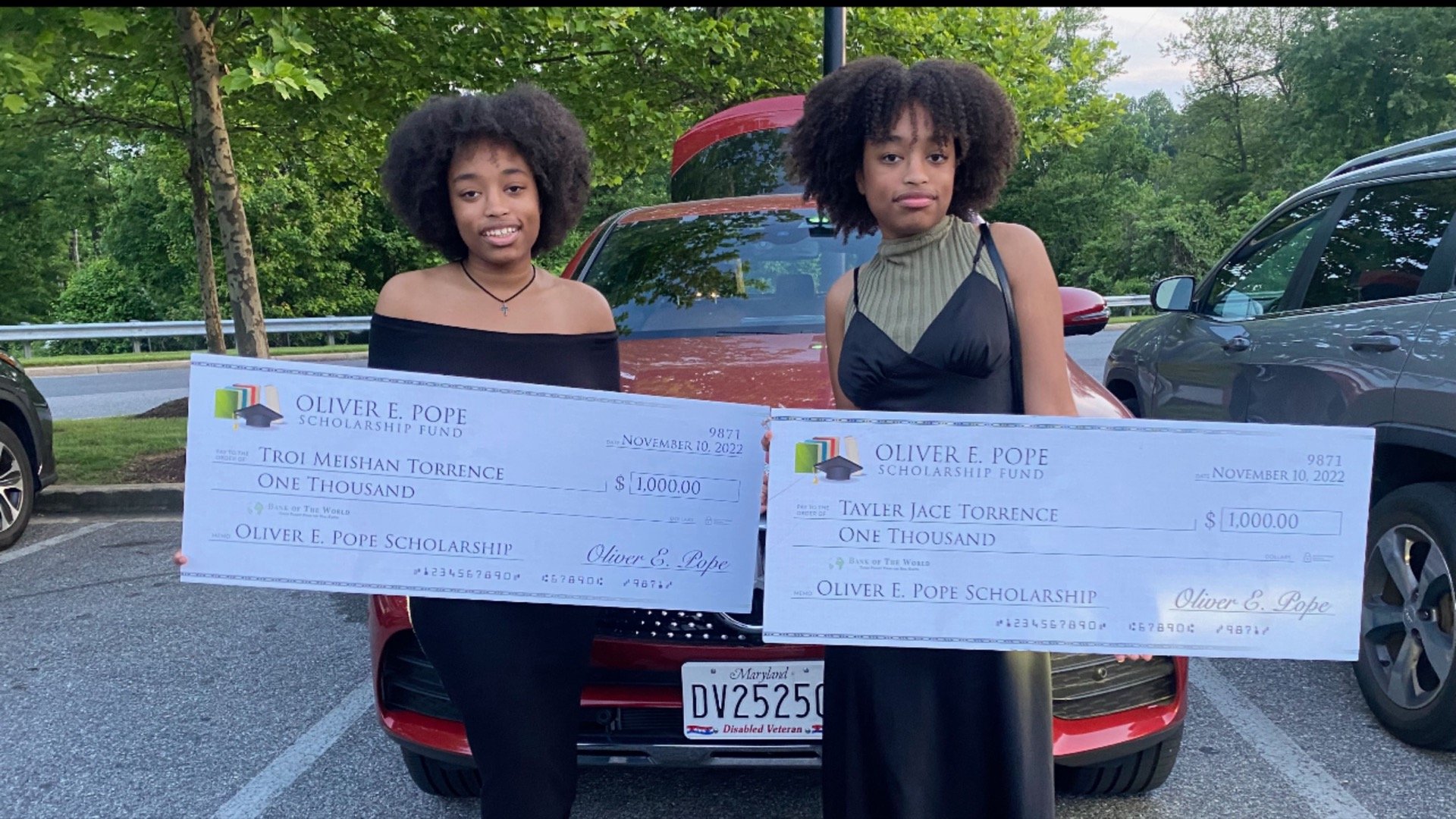 Two scholarship awardees holding their checks